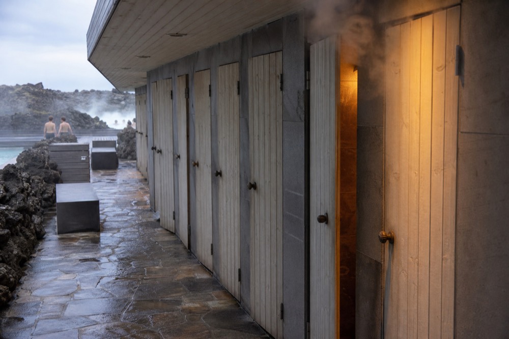 A row of private shower cubicles with wooden doors in an Icelandic bathing facility