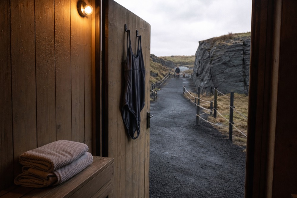 A private spa changing cubicle with a wooden bench and folded towels