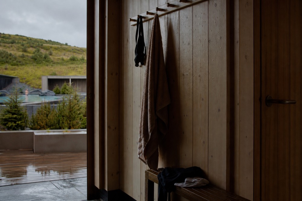 Towel hanging on a wooden hook beside a changing room door in a bathhouse