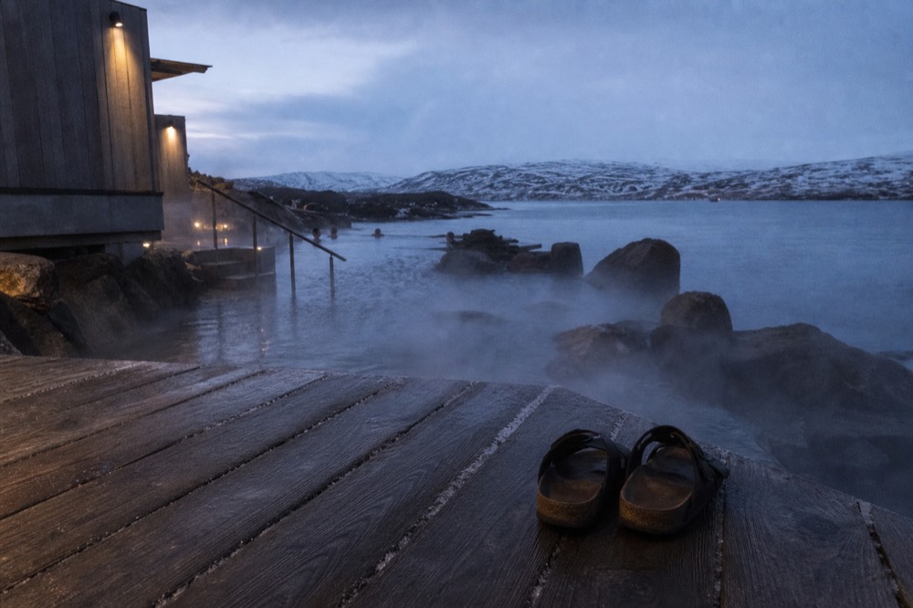 Wooden decking and steaming water at the edge of a geothermal pool