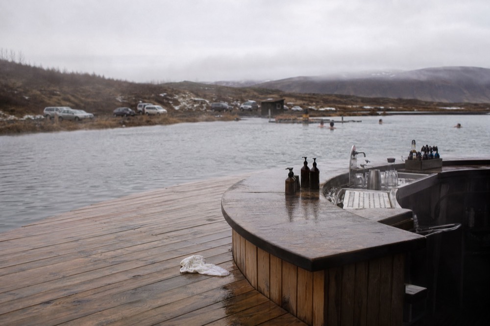An in-water bar counter at the edge of a steaming geothermal pool