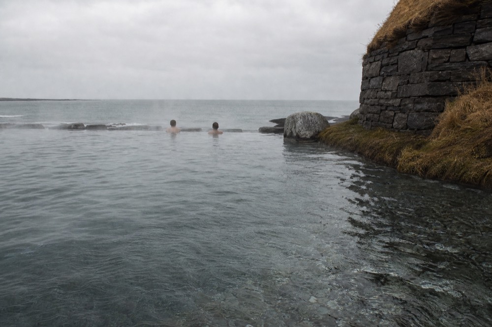 An infinity-edge geothermal pool overlooking a cold North Atlantic seascape