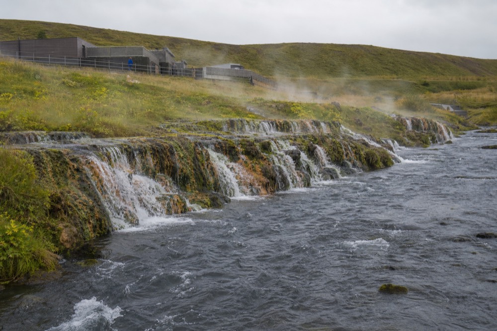 A series of waterfalls spreading across a lava rock ledge into a river