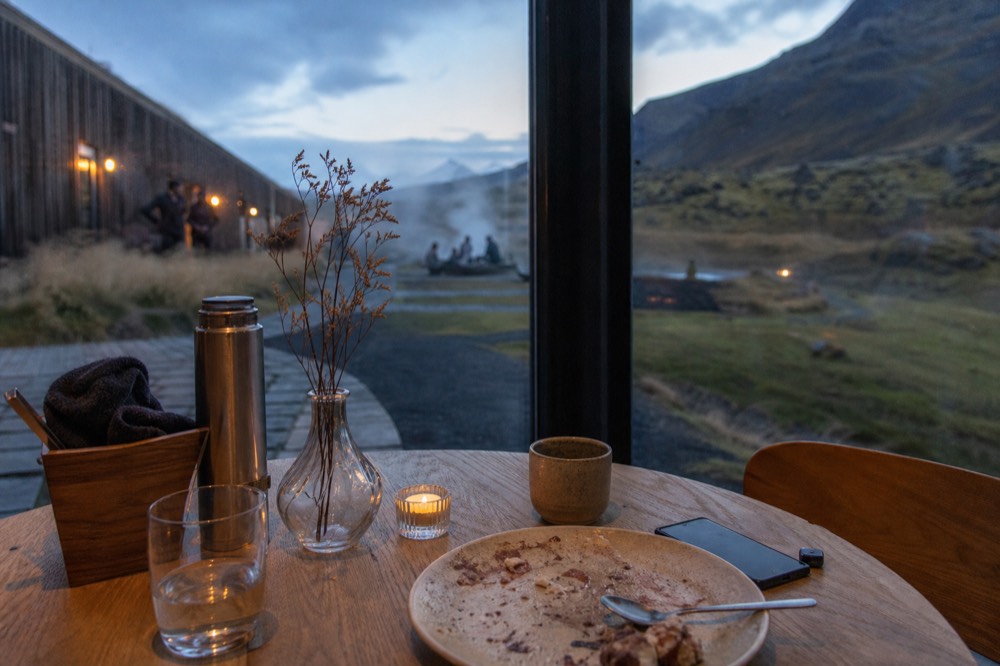 Restaurant table set beside panoramic windows overlooking a geothermal lagoon