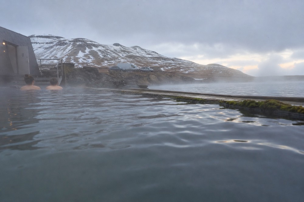 Steam rising from warm pool water against a cold lake surface